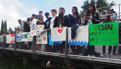 Students cheer on the boys varsity soccer team with posters celebrating the seniors.