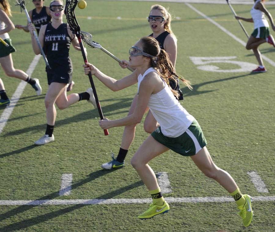 Freshman Elise Mayer catches the ball and runs during the girls first lacrosse match of the season.