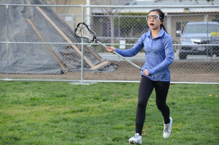 Freshman Heidi Zhang practices with the varsity lacrosse team Friday after school. All members joining lacrosse will be a part of the varsity team this year.