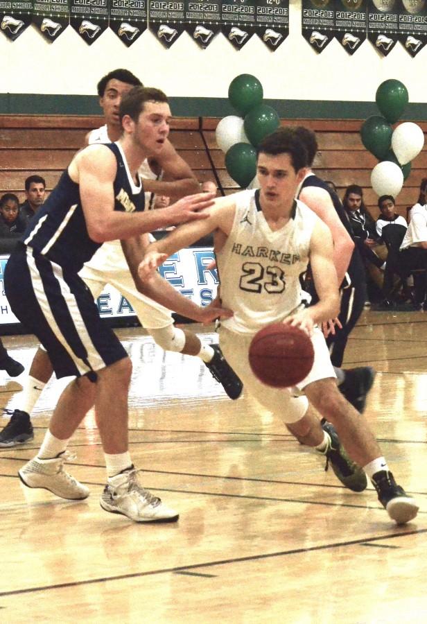 Senior Evan Lohn dribbles the ball around a defender during the boys' senior night game against Menlo. They lost 42-55.