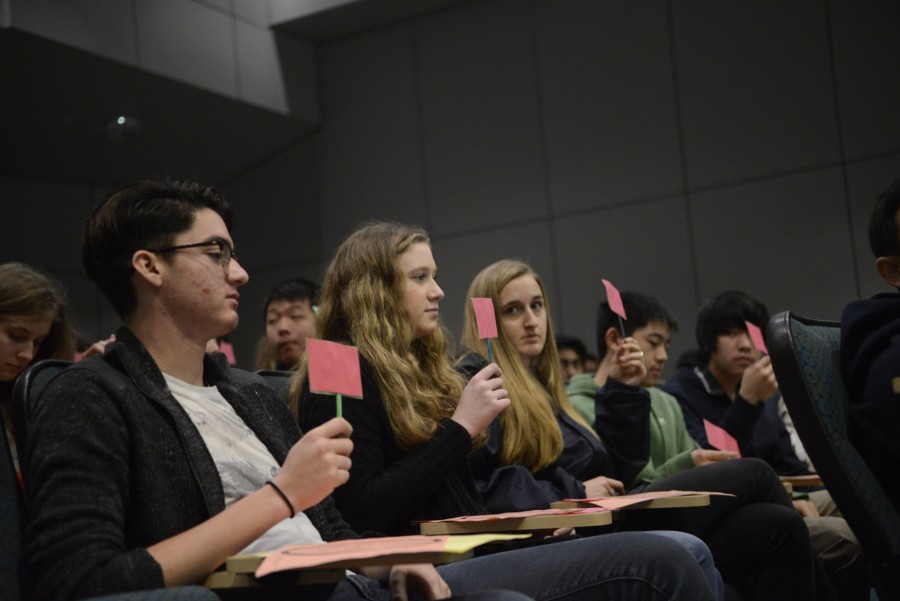 Students show the red side of their cards to answer no to a question asked by the Piece-It-Together presenters in the Nichols Auditorium. The presenters used a variety of techniques to explain abusive relationships and how to deal with them.