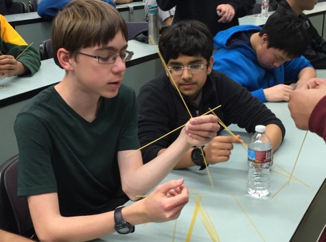 Freshmen Ryan Adolf, Ayush Alag, Bobby Bloomquist and Leon Lu work on constructing a tower out of uncooked spaghetti and duct tape as part of an activity run in between the two portions of the TEAMs competition. The tower had to support a marshmallow on top and the team with the highest tower received a bag of marshmallows as their prize.