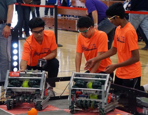 Freshmen Christopher Gong, Andrew Chang and Kaushik Shivakumar consider their robot during a VEX tournament. The team has won multiple awards at both the middle school and high school levels.