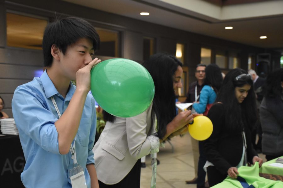 Students blow up balloons at a corporate exhibitor's booth. The 11th annual research symposium was held on April 9.