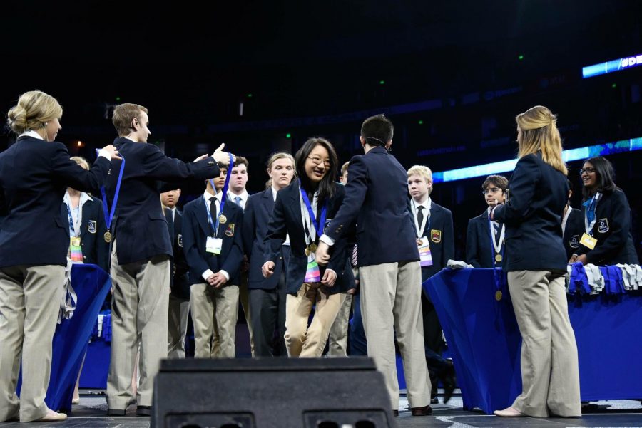 Enya Lu (9) steps forward to receive her medal after being called forward as an overall finalist in Principles of Finance. Later that evening, Enya earned first place, making Harker DECA history.
