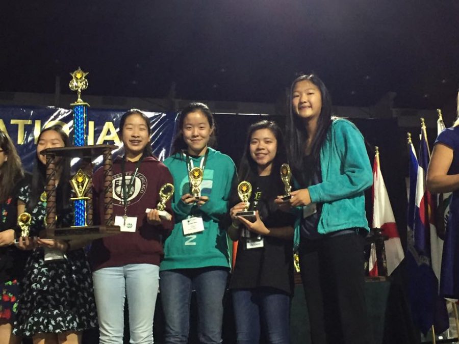 The FPS team smiles on stage with their second place trophy. The four students that competed placed second out of 78 teams at the international conference. 