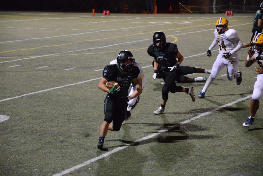 Senior Will Park runs past a Menlo defender. The Eagles lost their home opener 48-0.