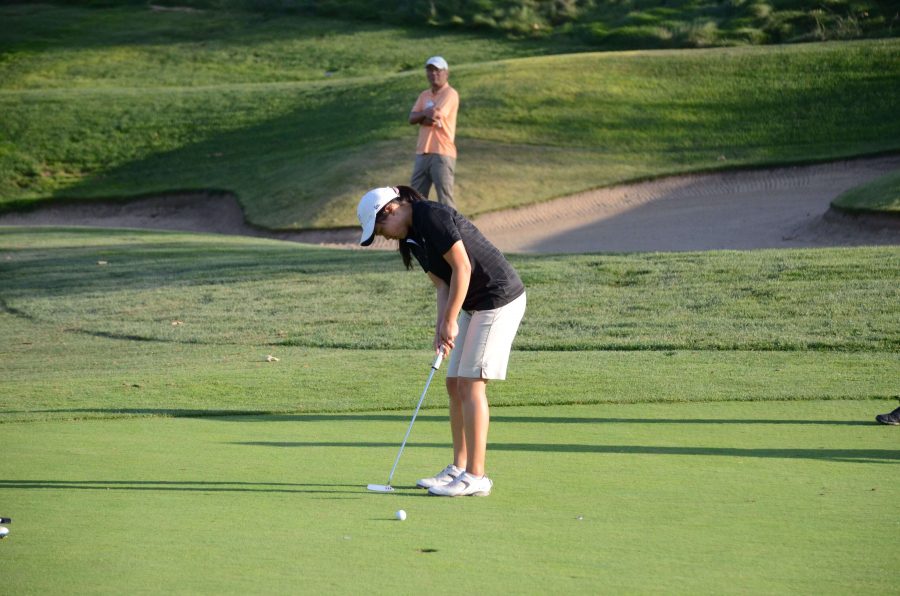 After putting the ball, Katherine Zhu (11) watches her ball as it rolls into the hole. The girls set a team score record in a 183-194 victory over Sacred Heart Prepatory on Wednesday.
