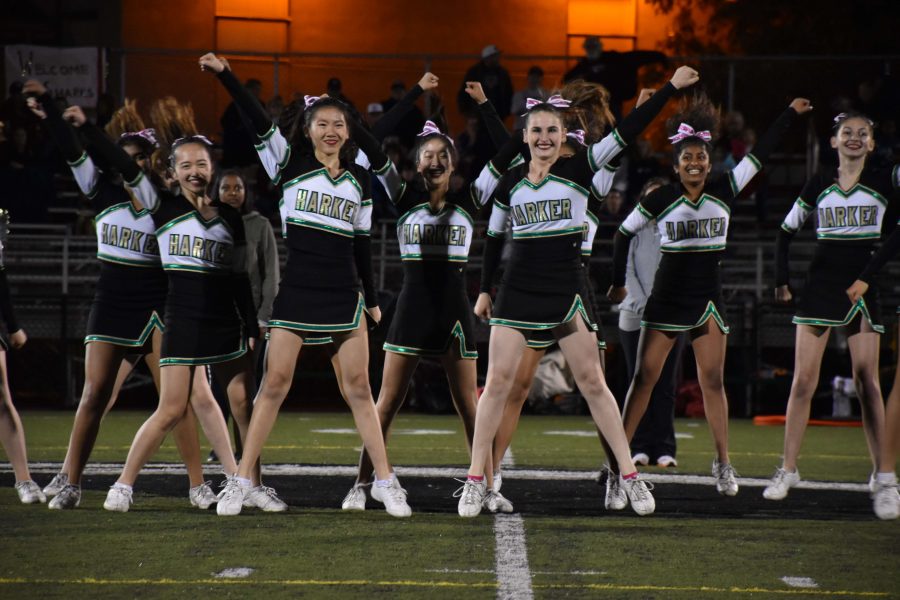 The cheer team performs a routine at a football game. The cheerleaders performed at football games in the fall and will perform at basketball games in the winter.