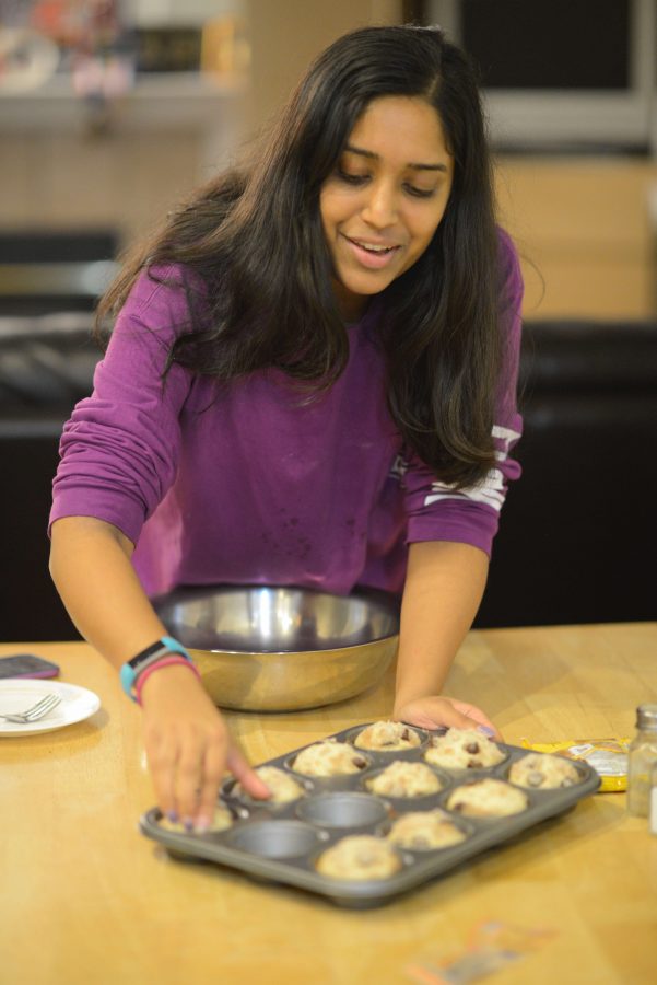 Anika Jain (12) puts dough in a muffin tin as she prepares to bake a batch of chocolate chip muffins.