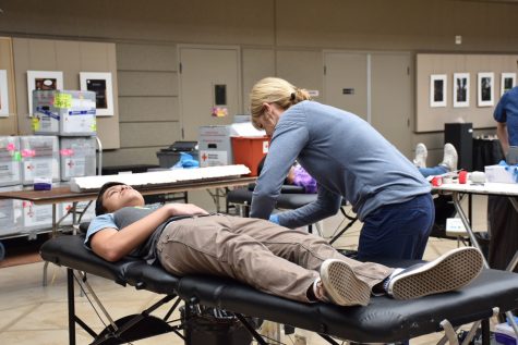 Michael Auld (12) lies down on an examination table as a Red Cross technician prepares him for the donation process. Signups for the 15-minute appointments began last Thursday.