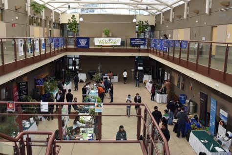 Attendees visit corporate booths in the Nichols Atrium. The annual Harker Research Symposium was held on Saturday. 
