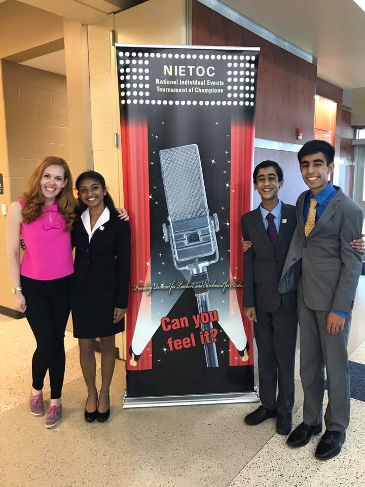 Nikki Solanki (9), Nikhil Dharmaraj (10) and Avi Gulati (9) pose with Harker speech coach Marjorie Hazeltine in front of a sign at NIETOC. Nikki competed in Dramatic Interpretation, while Nikhil and Avi both competed in Original Oratory.