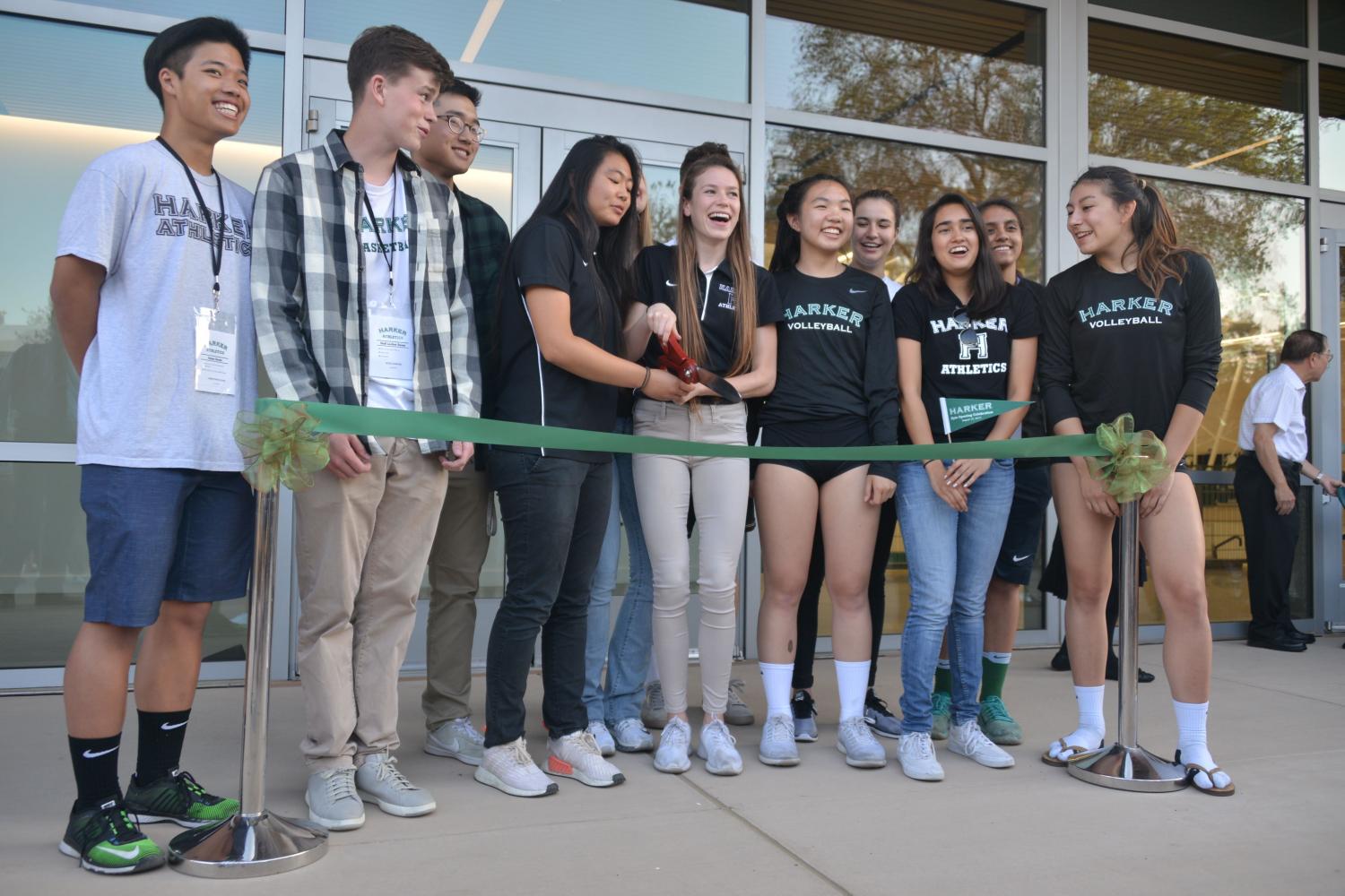 Student athletes pose for a ribbon-cutting ceremony outside the newly completed athletics center during the facility's opening ceremony. The performing arts center will be finished in January 2018 and open to student use in March 2018.