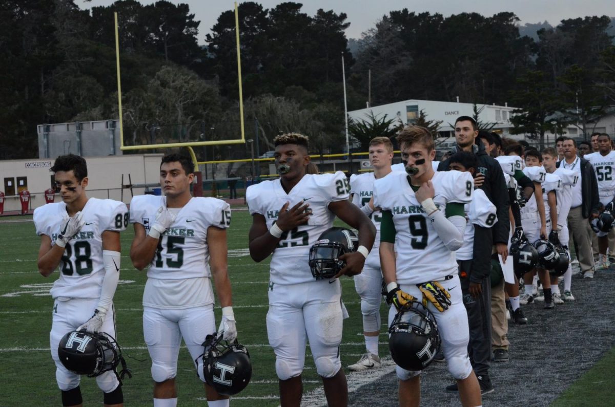 The team faces the flag and stands for the national anthem prior to the game. Harker beat Marina High School 30-0, maintaining their undefeated season record.