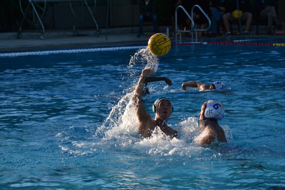 Senior Edgar Lin catches the ball while avoiding a Monta Vista player. The varsity boys’ water polo team won 14-6. 