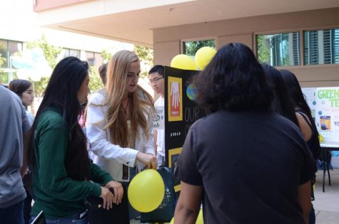 Isabella Spradlin (12) and Tiffany Shou (12) hand out balloons to passing students at the Amnesty International booth, a non-governmental organization which advocates for human rights. Several clubs gave out candy, balloons and other treats as a means of encouraging students to sign up.