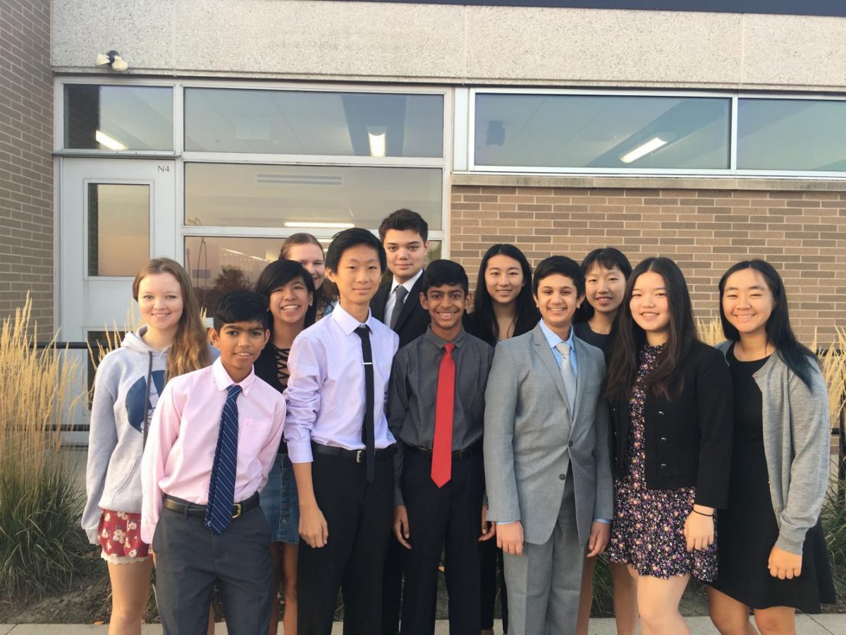 Harker debaters competing at the Valley Mid America Cup pose for a photo outside with former Harker Lincoln-Douglas debater Emmiee Malyugina ('17) and former Harker policy debater Molly Wancewicz ('17). A total of 10 Harker debaters attended the tournament.