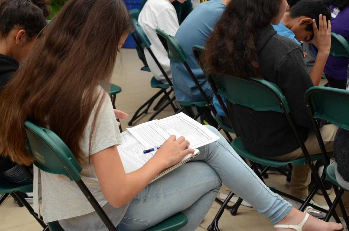 Zoe Kister (9) completes her paper course plan near the end of the LIFE assembly. “Mr. Barth particularly does a good job of saying that it’s possible to do too much. If you take all the classes, you miss the important part of having a creative educational life, media art teacher and freshman advisor Josh Martinez said.