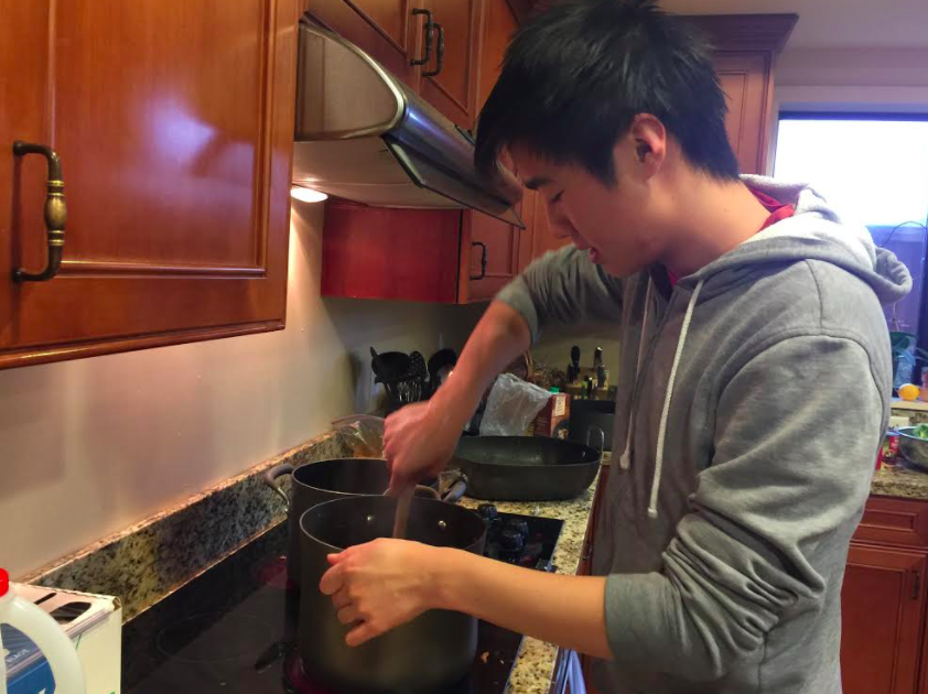 David Wen (12) stirs a pot as part of his next step in dinner preparations. David has been cooking once a month for the guests and staff at JW House. 