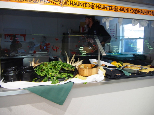 A kitchen staff member replenishes the salad bar. The salad bar is one of the few always vegan-friendly lunch options. 