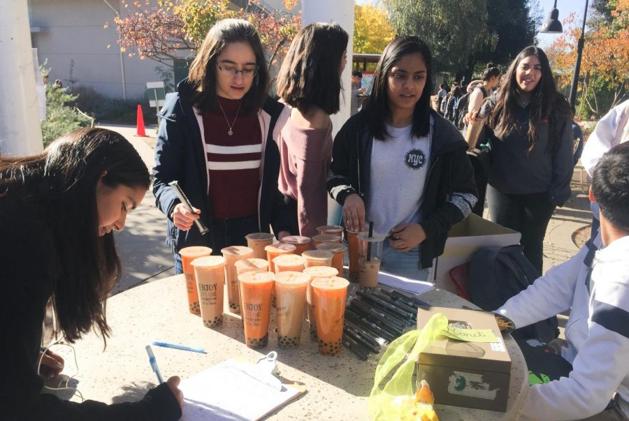 Red Cross Club officers Andrea Simonian (11) and Abha Patkar (12) sell boba from Teaspoon outside Manzanita. This week, Harker UNICEF also sold boba to raise money to support the Syrian refugee crisis.