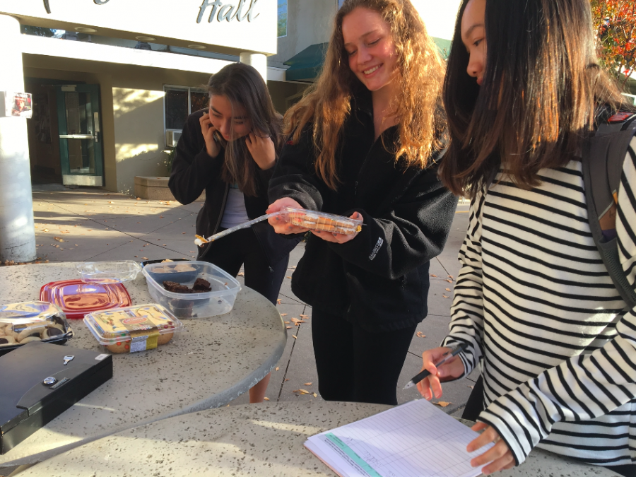 Cassandra Ruedy (10), Charlotte Blanc (10) and Katelyn Chen (10) examine the treats Make a Birthday Wish Club is selling outside Manzanita. “A birthday is a special thing that we all get to celebrate, and we want to make their birthdays as special as possible, club secretary Jenna Sanders (12) said.