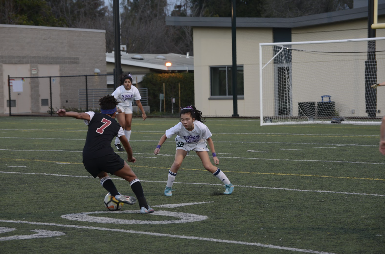 Defensive back Aria Wong (9) tracks the ball, defending the goal. Both boys and girls soccer teams wore special shirts for the occasion with their names and numbers on the backs and “Kicks Against Cancer” on the fronts.