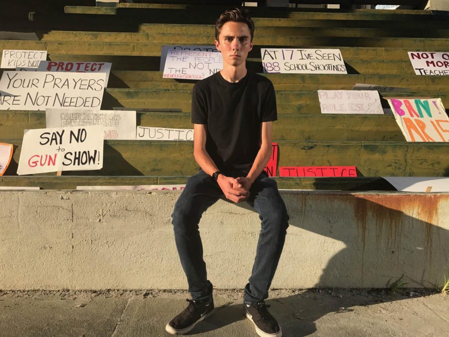 MSD student David Hogg sits in front of posters advocating for gun control after the Feb. 14 shooting. David is a leader and founder of the Never Again MSD movement.