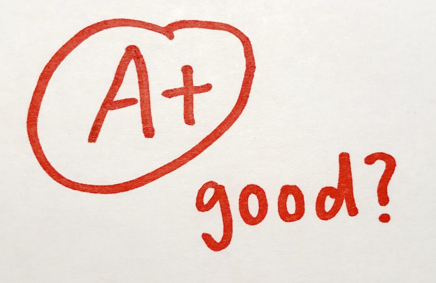 The drawing is of a test grade with a questioning remark, “good?”. Teachers write encouraging marks on high grades, but the question here conveys that the sacrifice of joy to get that grade might not have been worth it. 