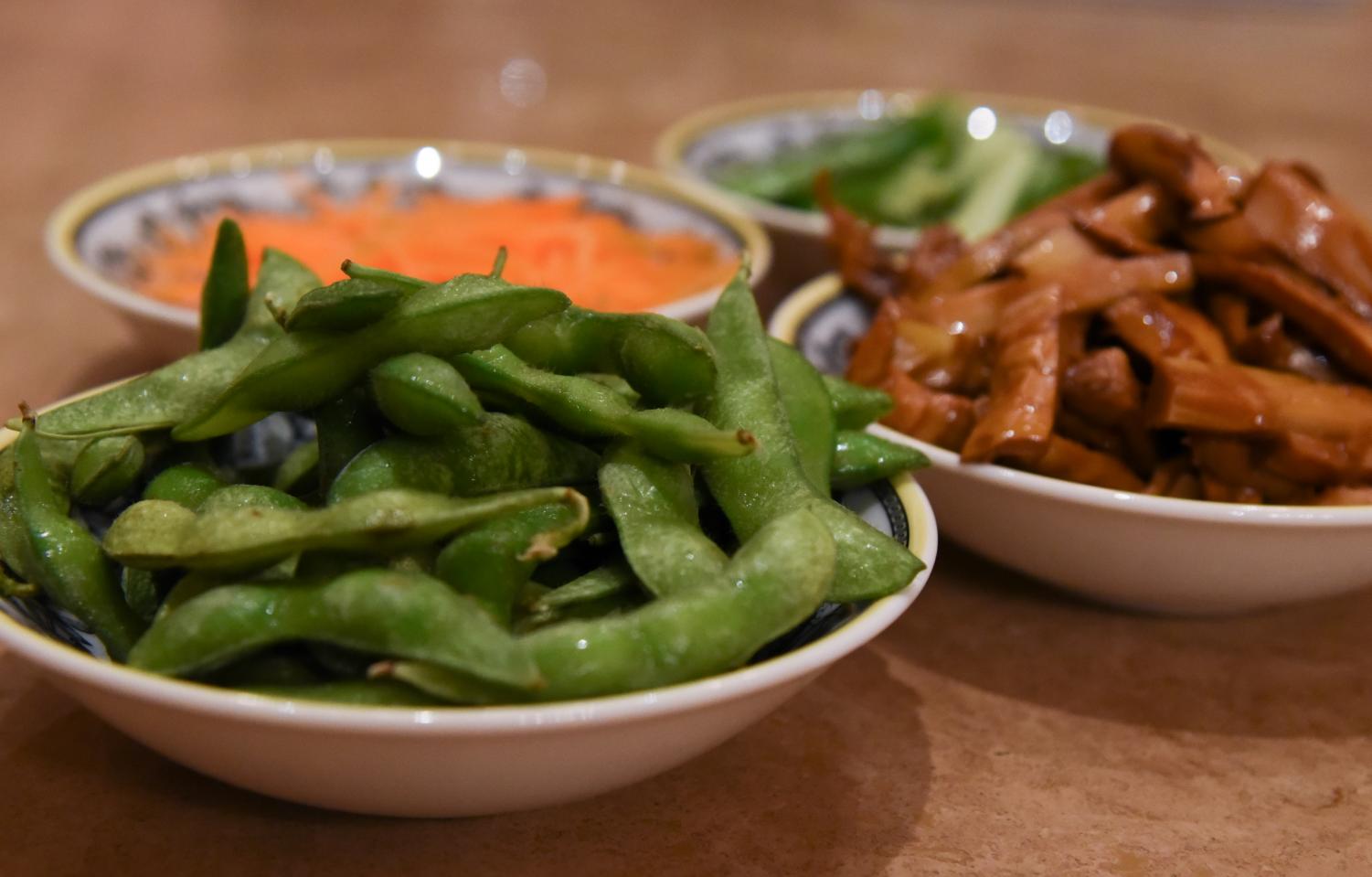 A lunch prep for a vegetarian meal consists of stir fry carrots, bamboo shoots, tofu, cucumbers and boiled edamame. Some Buddhists choose to eat only vegetarian foods on the first and 15th days of the Chinese lunar calendar.