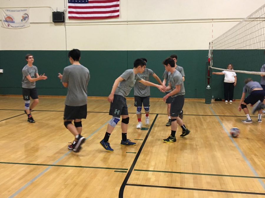 Members of the boys varsity volleyball team come together after a point. Bellarmine was the first team the boys played this season