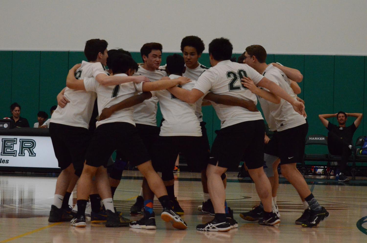 Between sets, the varsity boys volleyball team cheers within their huddle. They beat Cupertino High School in three sets.