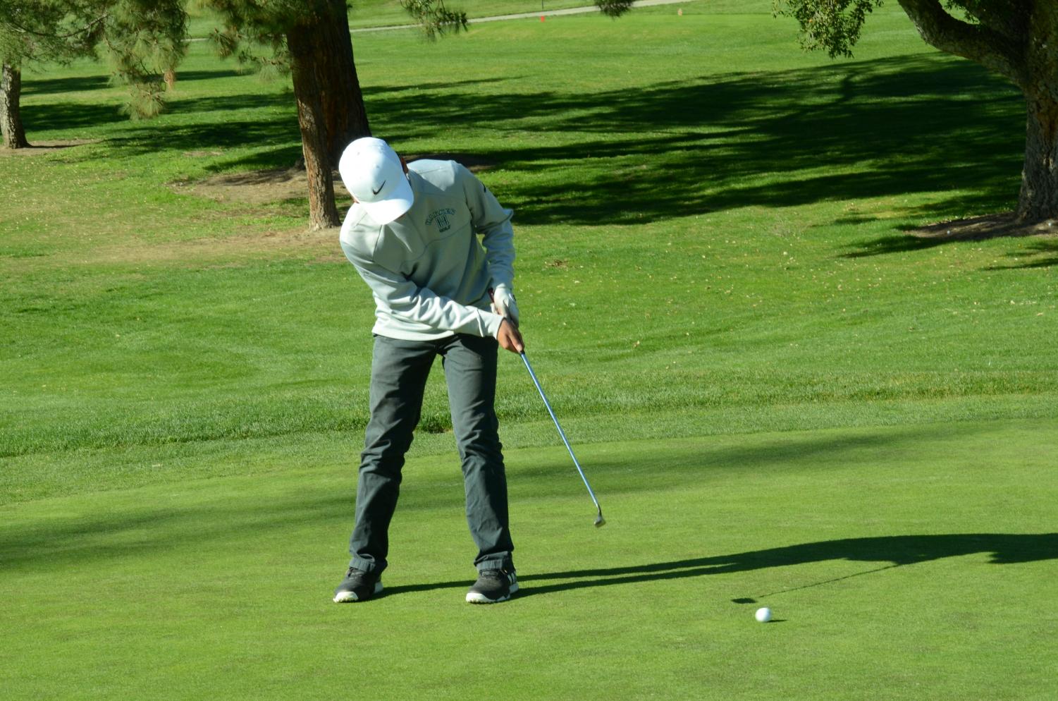 Gabe Yang (9) putts a golf ball across the San Jose Country Club's golf course. The boys' golf team played and defeated Nueva and Crystal Springs, keeping their undefeated streak of 6-0.