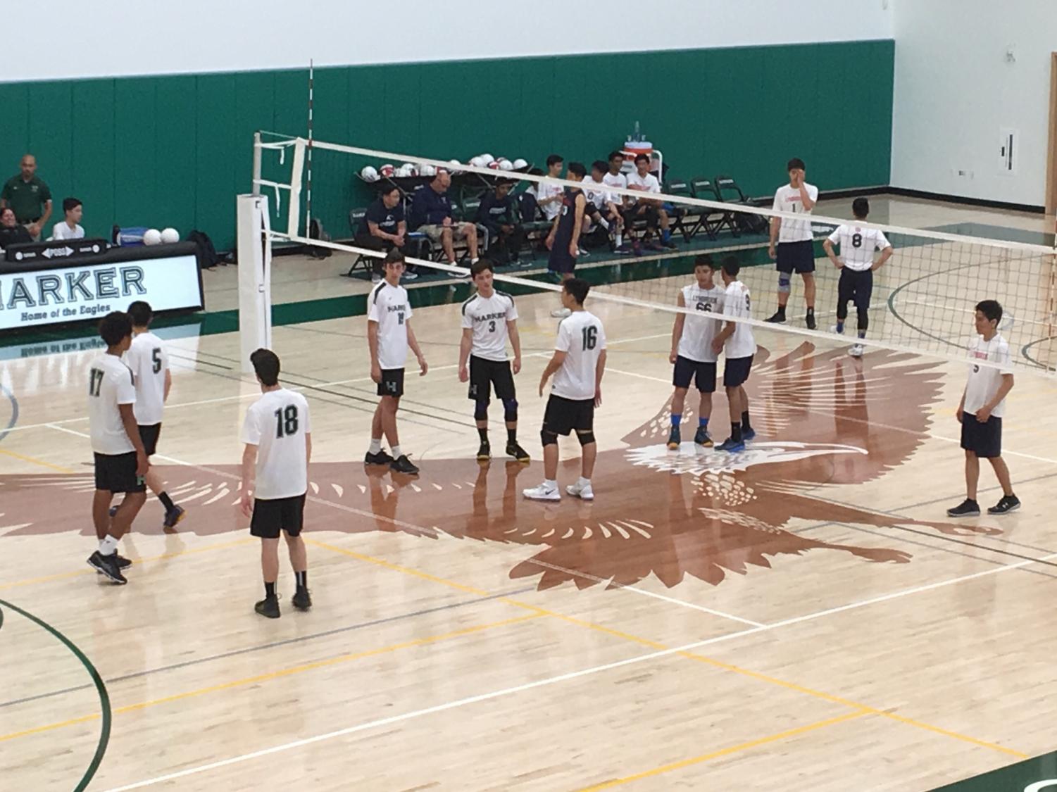 The varsity boys' volleyball game stands in position before the ball is served by the other team. They won their game against Lynbrook in three sets.