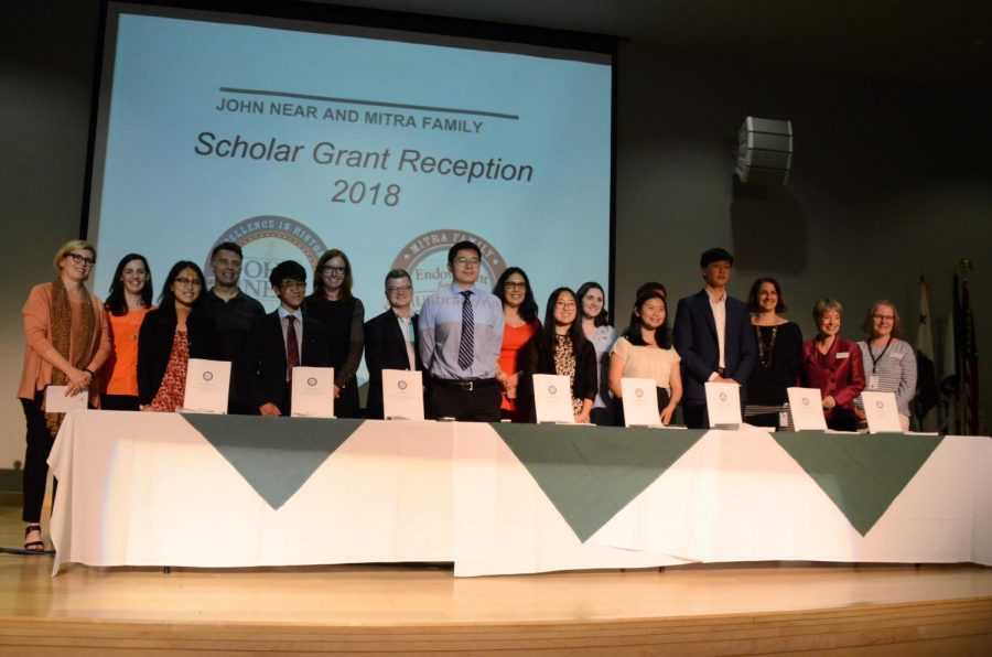Scholars Amy Jin (12), Derek Yen (12), Matthew Lee (12), Serena Lu (12), Jacqueline He (12) and Alan Jiang (12) pose for a group photo with their research mentors on the Nichols Auditorium stage. As scholars Andrew Semenza (12) and Emily Chen (12) were unable to attend the event, Derek read Andrews speech for the ceremony, while Emily sent in a video recording of her speech to be played at todays event.
