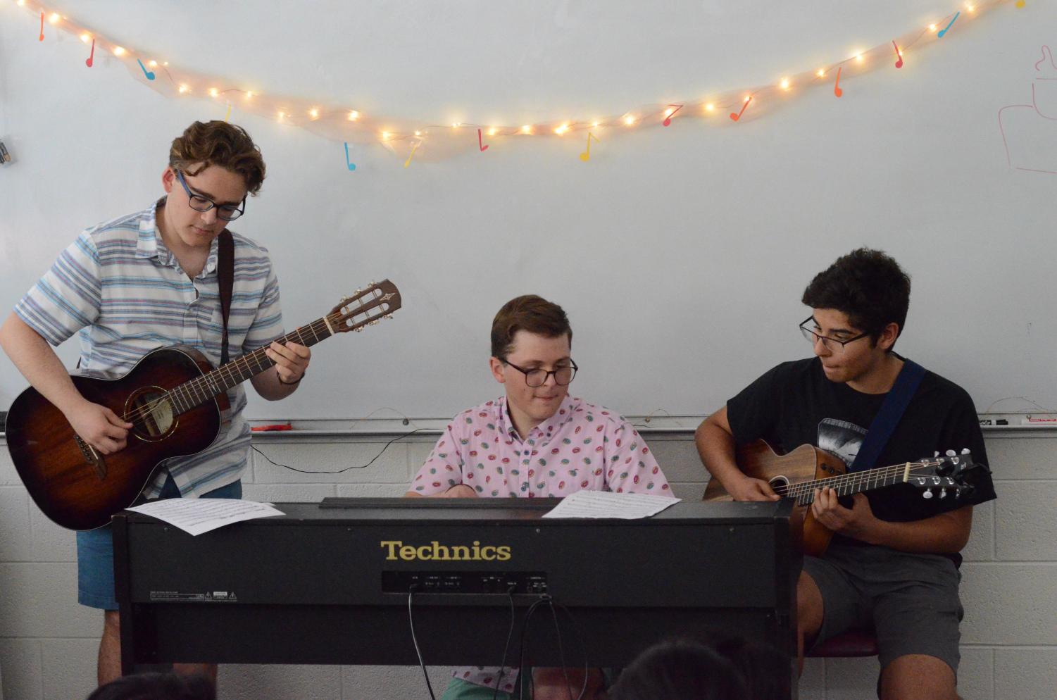 William Rainow (10), Thomas Rainow (10) and Joshua Valluru (10) play a Brazilian song together across their instruments. The Music Around the World showcase was held in English teacher Christopher Hurshman's room on April 24.