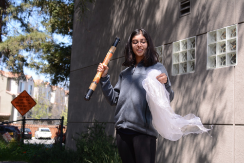 Aditi Khanna (10) waves a white scarf and shakes a rainstick to represent calling in the Spirit of the East, which represents air. Each student brought in visual representations of the element they were assigned to.