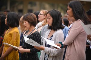 Freshman adviser Yumiko Aridomi and members of the class of 2022 recite the matriculation oath at the matriculation ceremony in the upper school’s quad on Aug. 24.