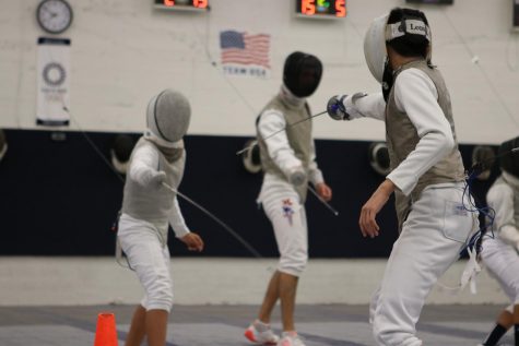 Ethan (right) faces off against another fencer at practice. A fencing bout in foil occurs in three rounds of three minutes each, with victory being awarded to the first person to reach 15 points. 