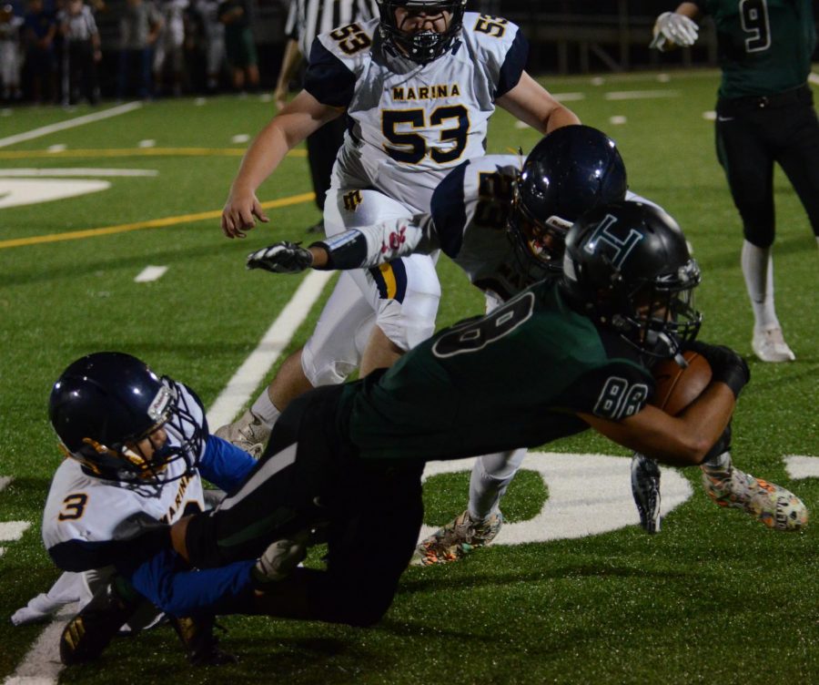 Wide receiver Mitchell Granados (12) is tackled  by defensive Mariners players. "Mitchell has a ton of good plays every week. He doesn’t get a lot of touchdowns because of the position that he plays, but he makes a lot of crucial conversions for us on offense and a lot of great tackles and plays on defense," head coach Mike Tirabassi said. 