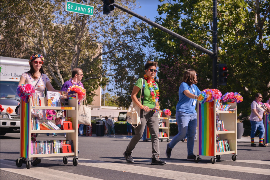 Marchers representing a public library roll shelves of books down the road at the parade. 