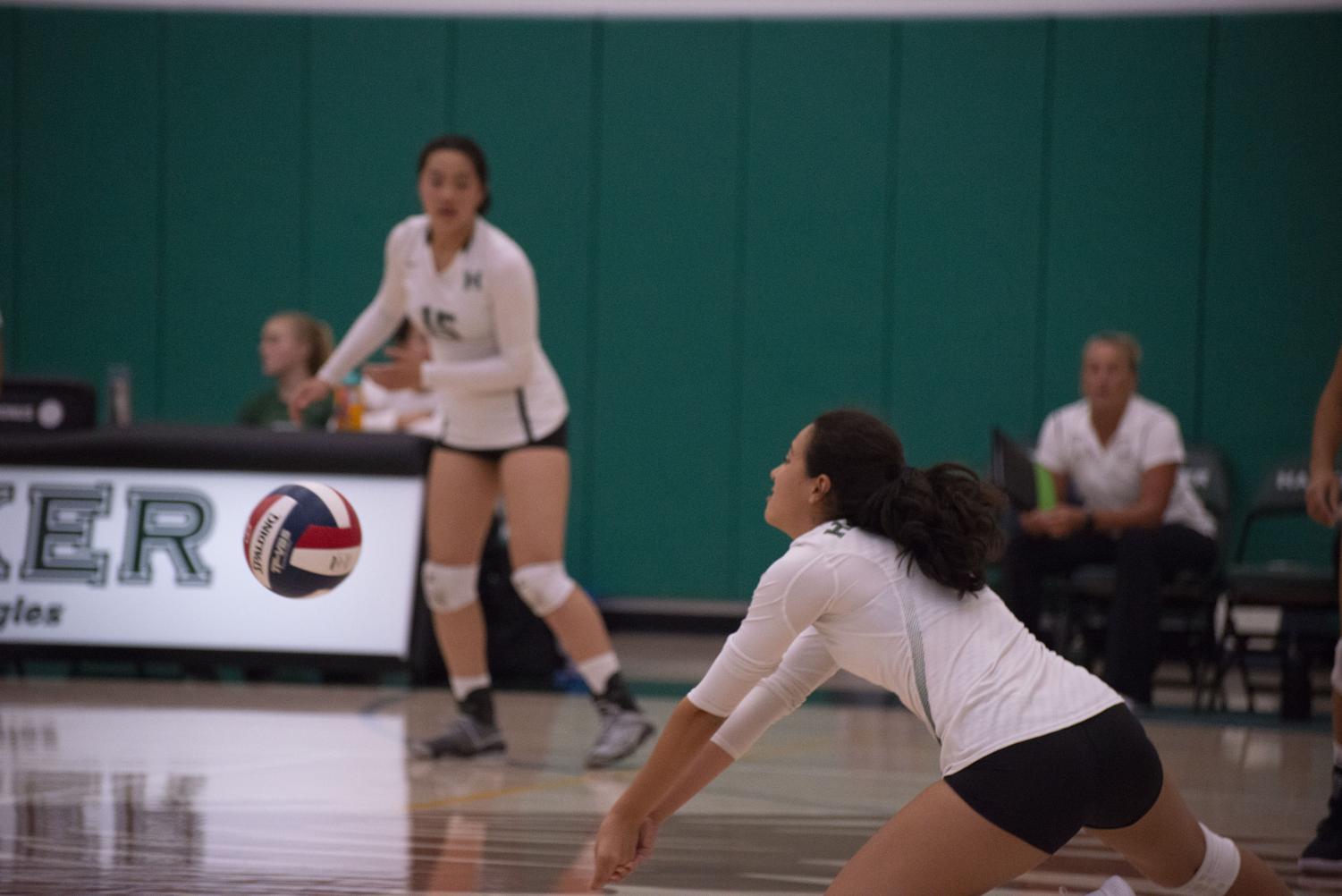 Emma Dione (10) dives for the ball as Michelle Ning (10) watches on. The varsity girls volleyball team defeated Westmont in four sets on Friday, the respective scores being 25-22, 18-25, 25-11 and 25-15.