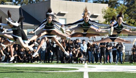 Cheerleaders leap in the air during their routine. After their performance, the classes competed in a scream-off.