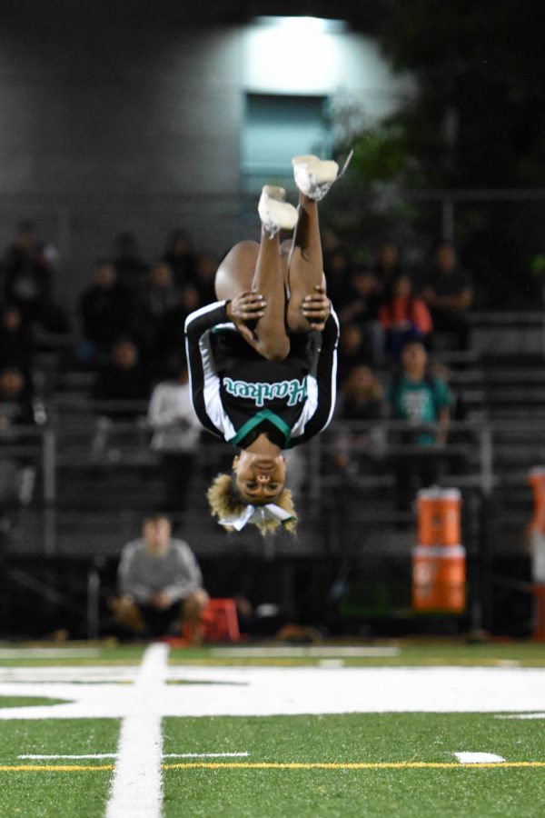 Lilly Anderson (12) performs a flip during a halftime cheer performance during the homecoming game. Cheer held their senior night yesterday at 6:45 before the home football game against Oakland Military Institute.