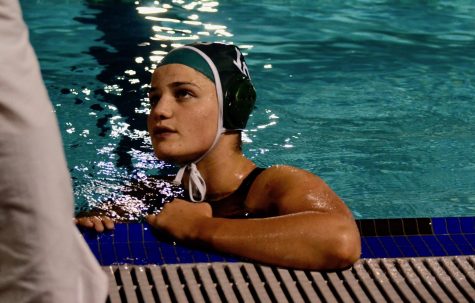 Abigail Wisdom talks to a coach during a game. After we won, everyone sprinted out of the water, and we pushed our coach into the pool. Some of the seniors got emotional because it meant a lot to win leagues for the first time in a few years and to just see how far the team has come,” Elizabeth Fields (10) said. 
