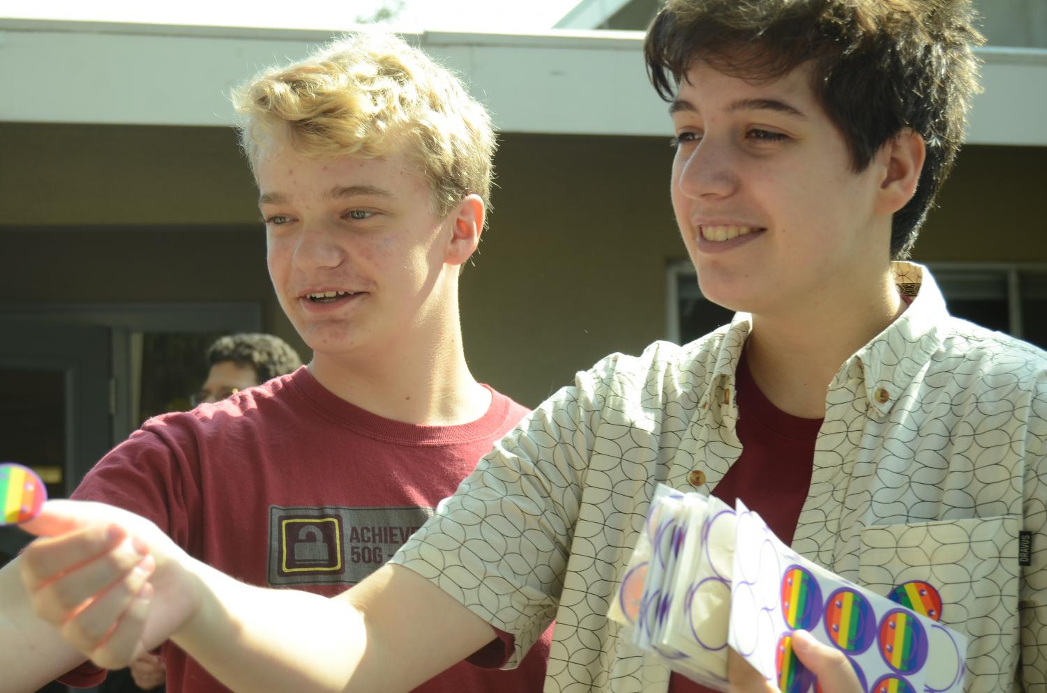 Raphael Sanche (12) and Evan Bourke (10) hand out rainbow smiley face stickers on behalf of GSA club during lunch. “As an ally of our young people who are coming along the process, it means that I get to witness firsthand the growth within our own student body as they’re moving forward and understanding themselves and embracing themselves and being more public with who they are,