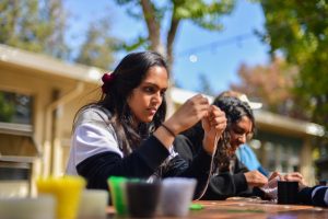 Junior Sejal Krishnan strings a bead onto a friendship bracelet at an activity hosted by spirit club today during lunch. Students are invited to participate in a number of spirit activities this week, including a parade and scream-off tomorrow after fifth period.