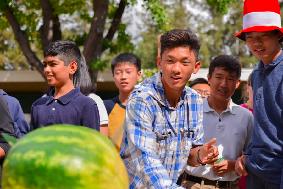 A freshman class representative throws a card at the face of a watermelon. The freshmen won the 
