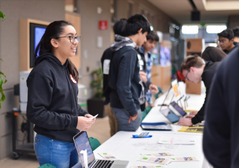 Maya Shukla (11) presents her service opportunity to students walking by. The fair took place after advisory on Nov. 12.